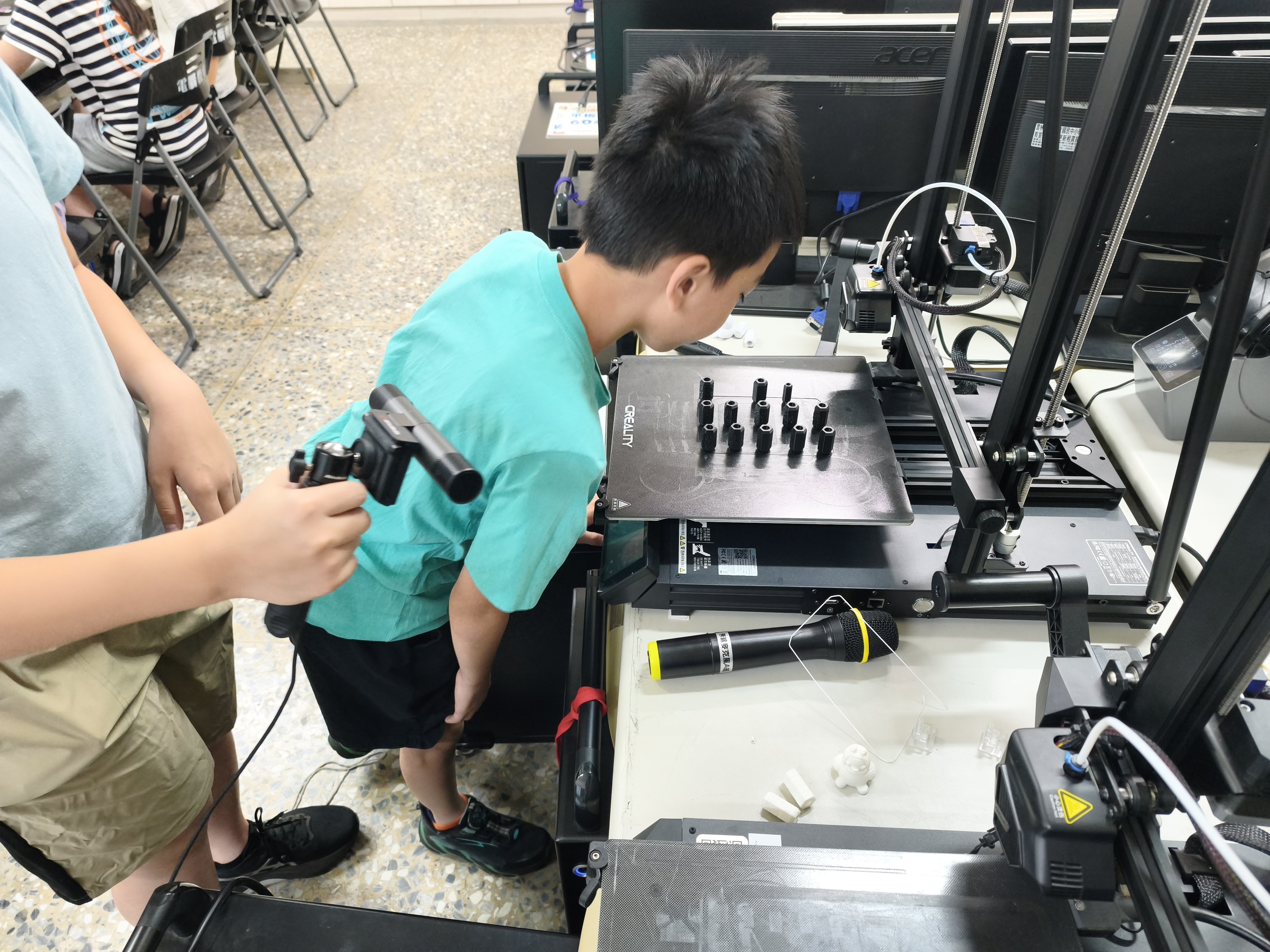 學生觀察黑色 3D 列印筆蓋