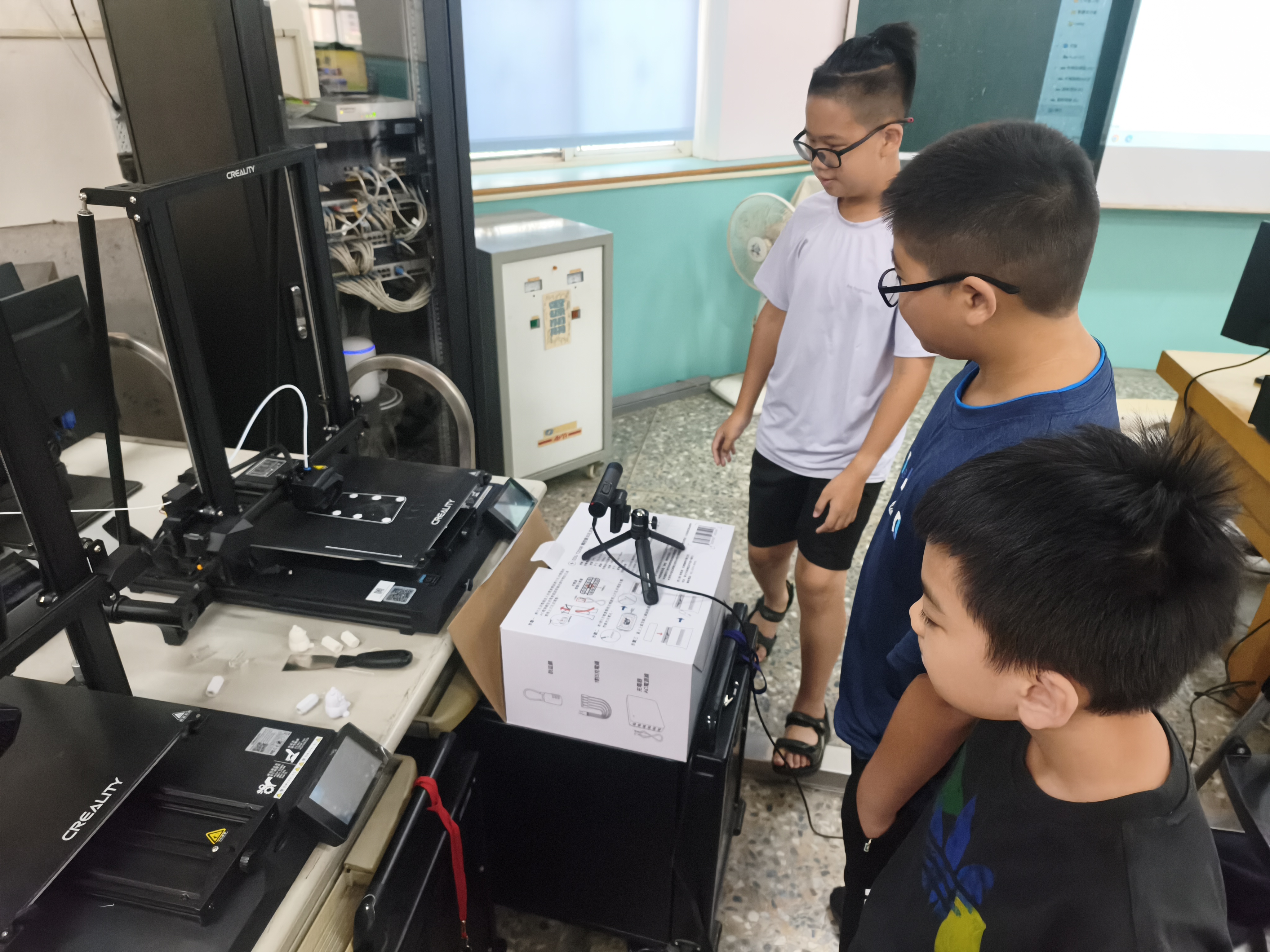 學生圍觀 3D 列印機運作